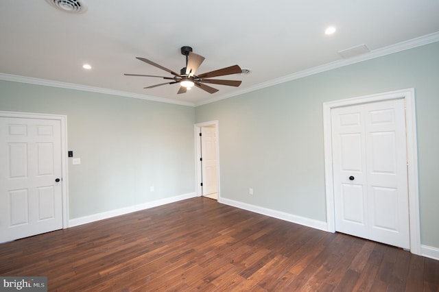 spare room with visible vents, dark wood-type flooring, ornamental molding, a ceiling fan, and baseboards