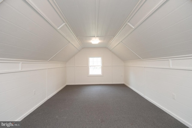 bonus room featuring lofted ceiling and dark carpet