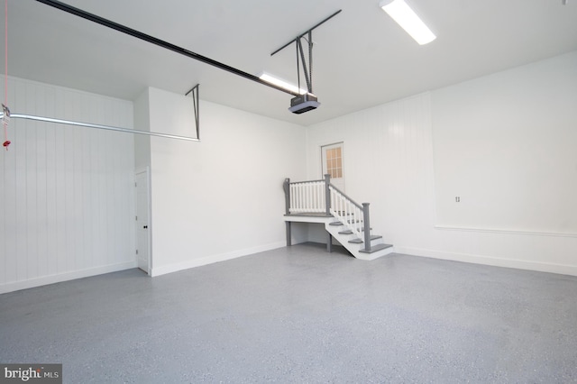 garage featuring a garage door opener and baseboards