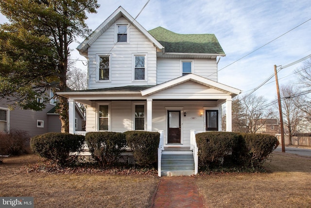 view of front of property featuring covered porch and a shingled roof