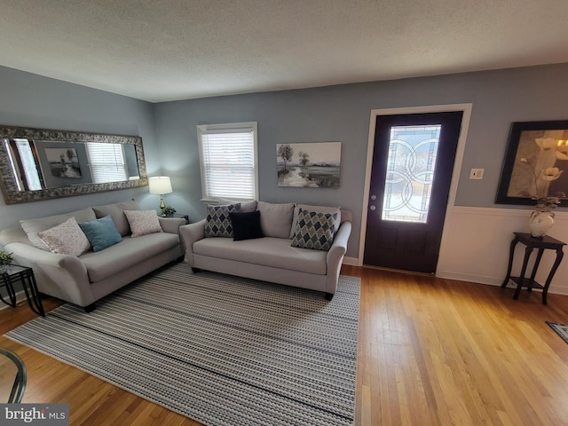 living room featuring a textured ceiling and light wood finished floors