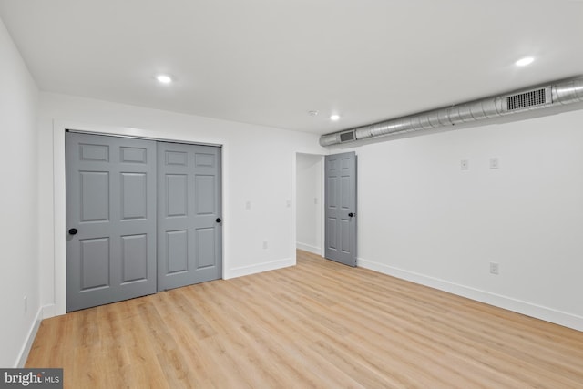 unfurnished bedroom featuring light hardwood / wood-style floors and a closet