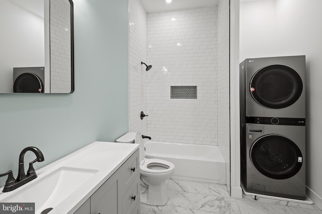 full bathroom featuring tiled shower / bath combo, toilet, stacked washer and dryer, and vanity