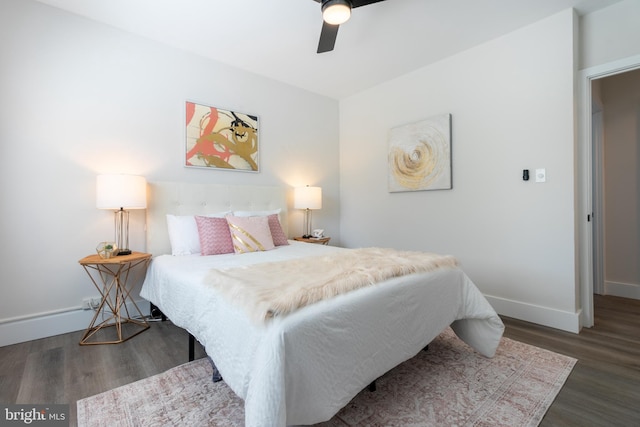 bedroom featuring ceiling fan, dark wood-style flooring, and baseboards