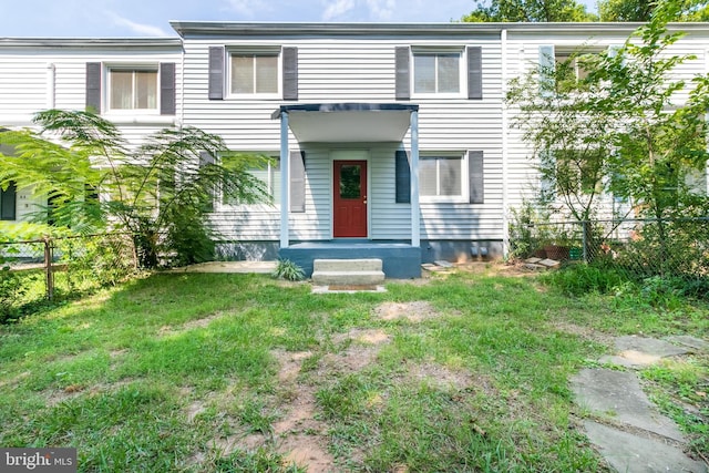 view of front of property featuring fence and a front lawn