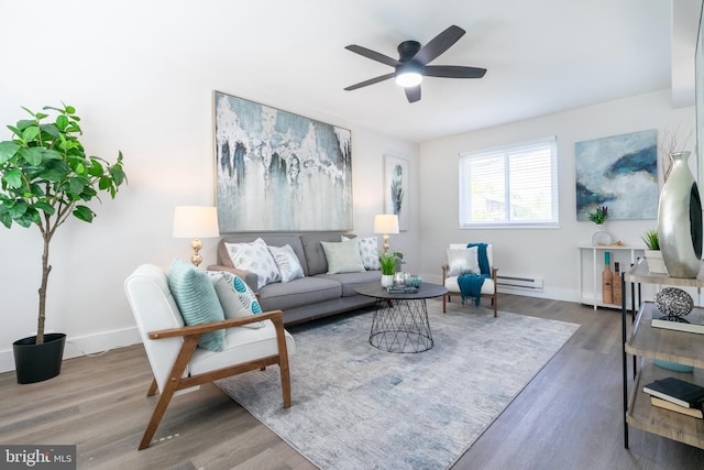 living room with dark wood-style floors, baseboards, a ceiling fan, and a baseboard heating unit