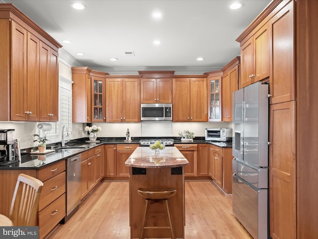 kitchen with brown cabinets, light wood finished floors, and stainless steel appliances