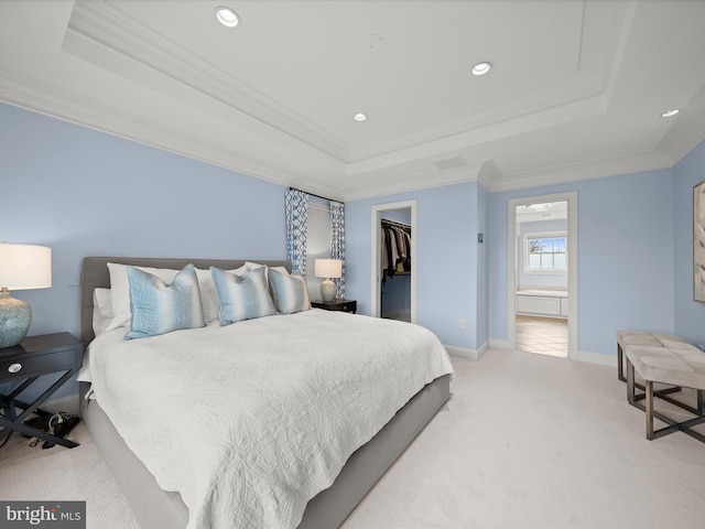 bedroom featuring baseboards, a raised ceiling, a spacious closet, crown molding, and carpet flooring