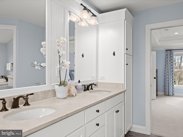 full bathroom featuring a sink, baseboards, and double vanity