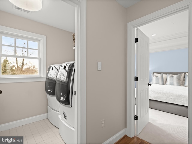 washroom featuring laundry area, visible vents, baseboards, and separate washer and dryer