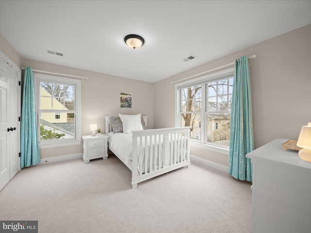 carpeted bedroom with visible vents and baseboards