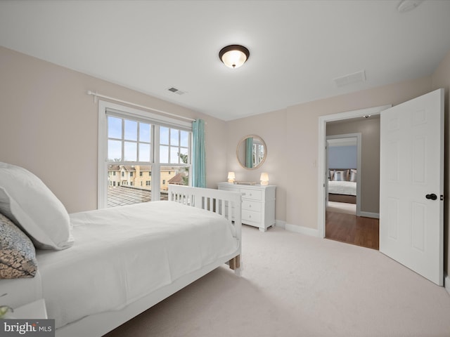 carpeted bedroom featuring visible vents and baseboards