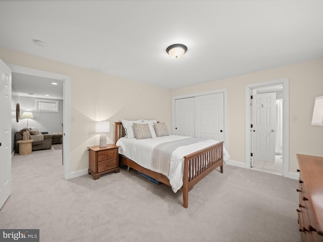 bedroom featuring baseboards, a closet, and light colored carpet