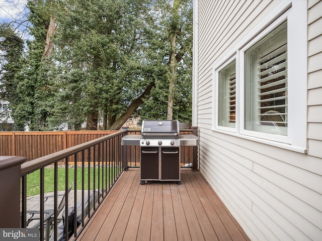 deck with a grill and fence