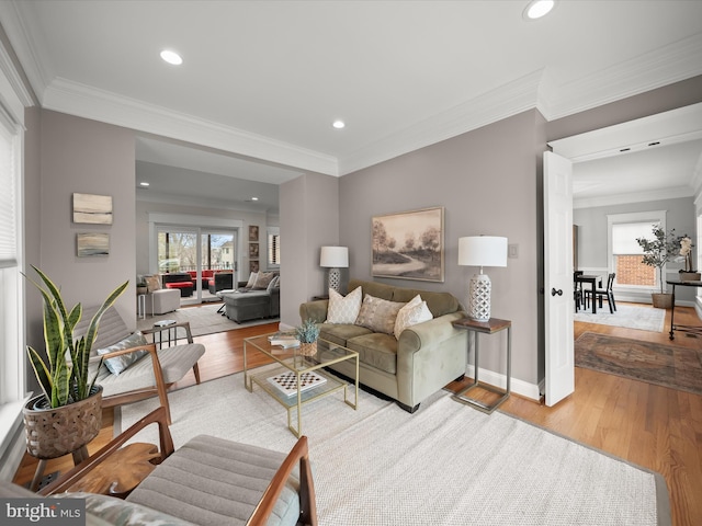 living area featuring light wood-style flooring, crown molding, and recessed lighting