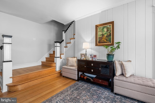 living area with stairs, wood finished floors, and baseboards