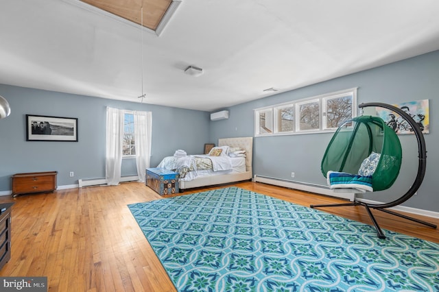 bedroom with a baseboard radiator, hardwood / wood-style flooring, attic access, and multiple windows