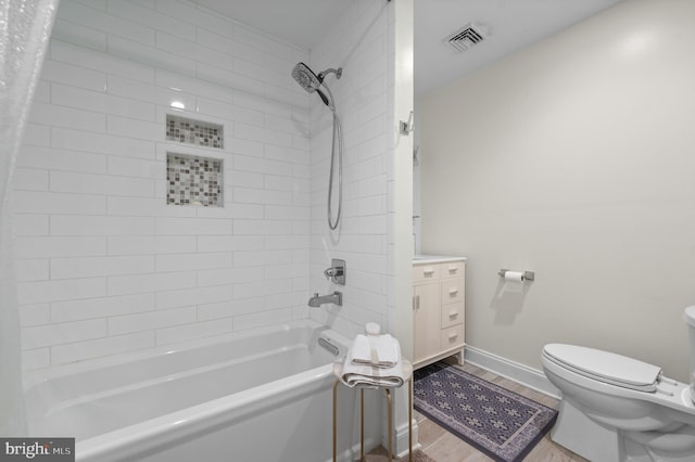 bathroom with toilet, wood finished floors, visible vents, baseboards, and shower / tub combo with curtain