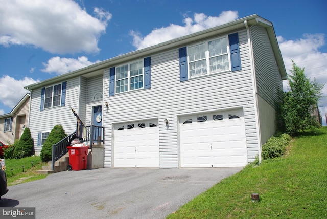 bi-level home with asphalt driveway, a garage, and a front lawn
