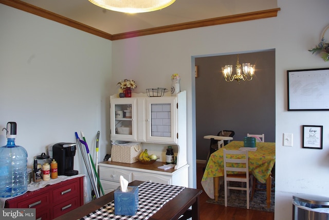 dining area featuring a chandelier, crown molding, and wood finished floors