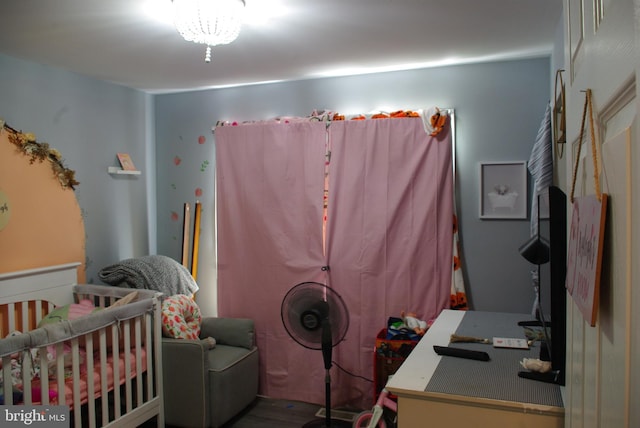 bedroom featuring wood finished floors and a nursery area