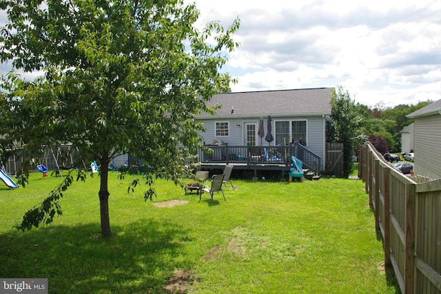 back of property featuring a wooden deck, an outdoor fire pit, and roof with shingles