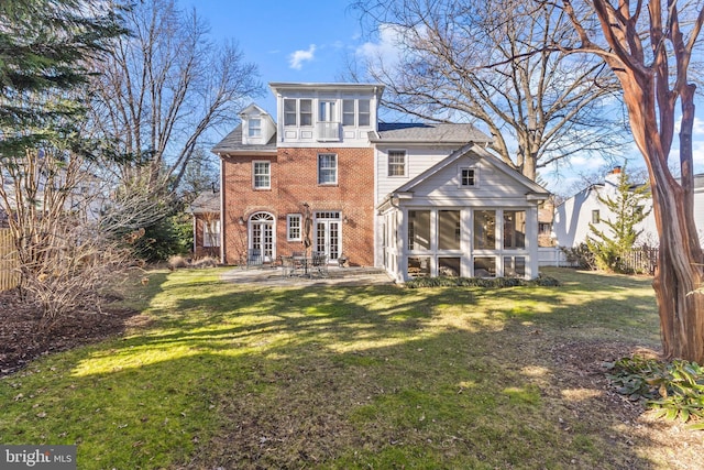 rear view of property with a patio, a sunroom, and a lawn