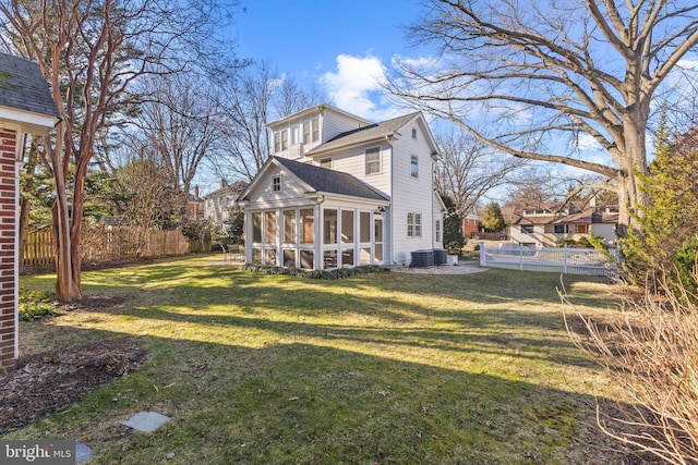 back of house featuring a lawn and a sunroom