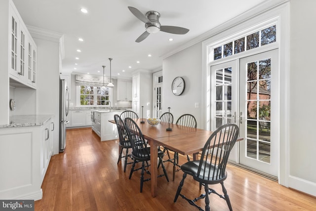 dining room with light wood-type flooring, french doors, ceiling fan, and ornamental molding