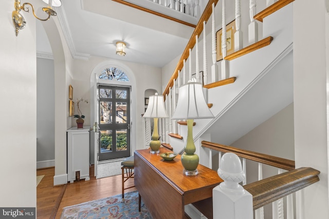 foyer with crown molding and wood-type flooring