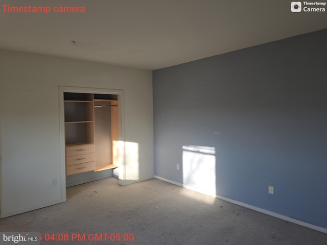 unfurnished bedroom with a closet, light carpet, and baseboards