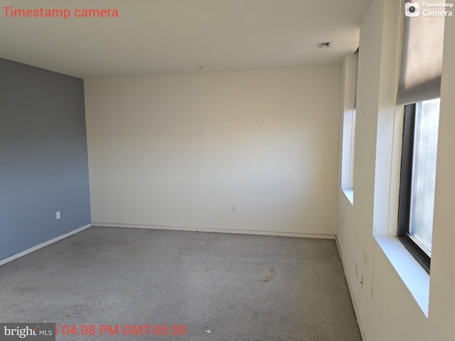 spare room with light carpet and baseboards