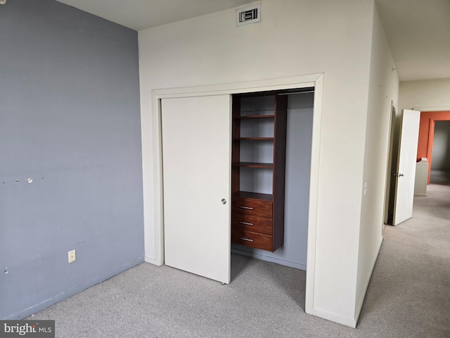 unfurnished bedroom with a closet, light carpet, visible vents, and baseboards