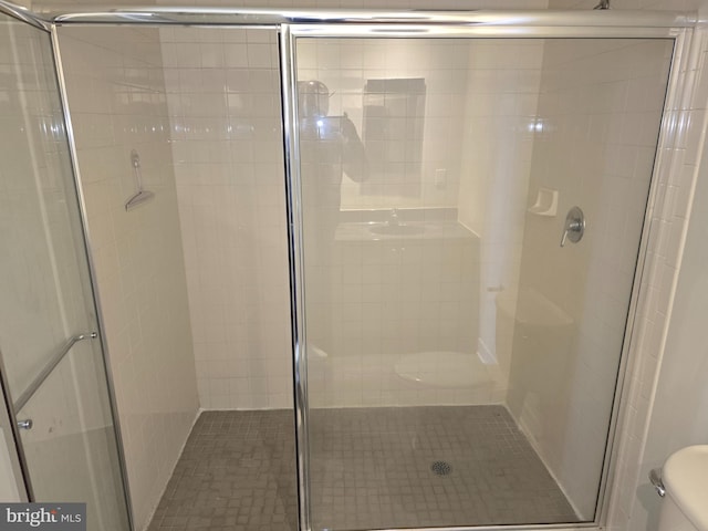 full bathroom featuring a stall shower and toilet