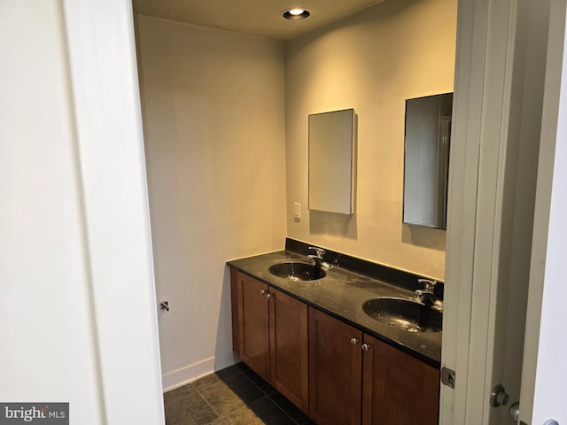 full bathroom with double vanity, baseboards, a sink, and tile patterned floors