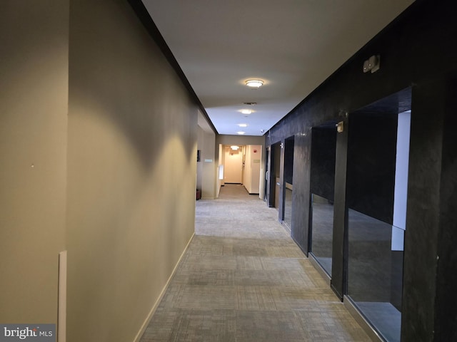 hall with light carpet and baseboards