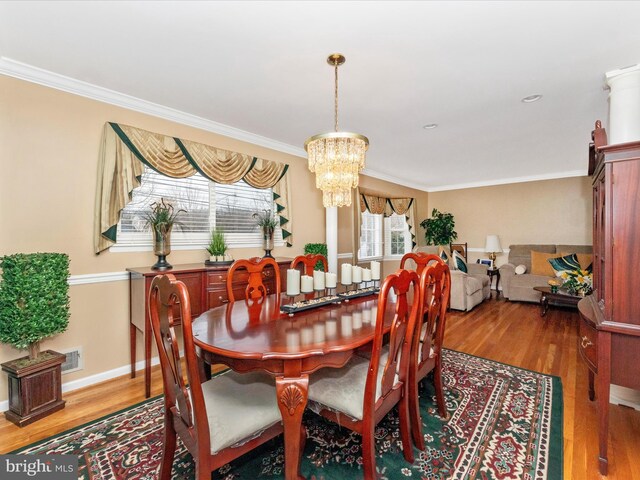 dining area with a chandelier, baseboards, wood finished floors, and crown molding