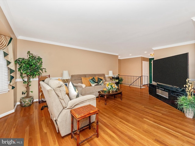 living area with light wood-type flooring, crown molding, and baseboards