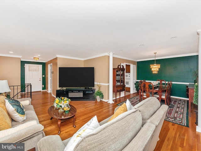 living area featuring baseboards, wood finished floors, and crown molding