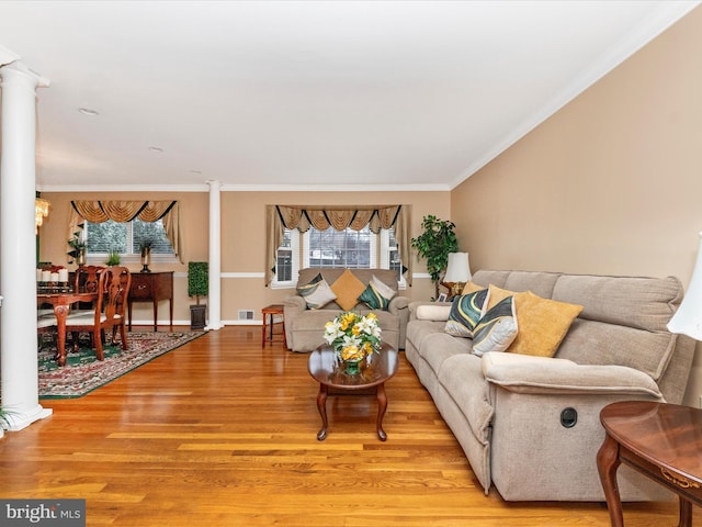 living room featuring crown molding, ornate columns, visible vents, light wood-type flooring, and baseboards