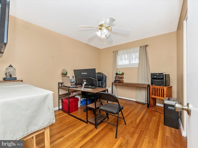 office space featuring wood finished floors, a ceiling fan, and baseboards