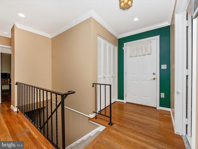 foyer entrance with ornamental molding, recessed lighting, baseboards, and wood finished floors