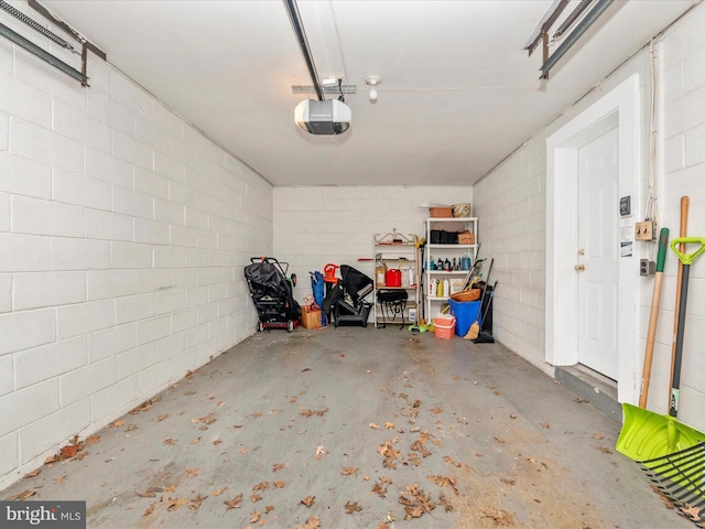 garage with concrete block wall and a garage door opener