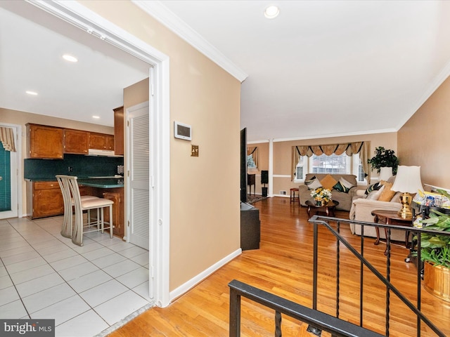 corridor with light wood-style floors, baseboards, crown molding, and recessed lighting