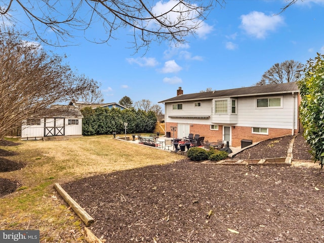 rear view of property featuring a chimney, an outbuilding, a storage unit, a patio area, and brick siding