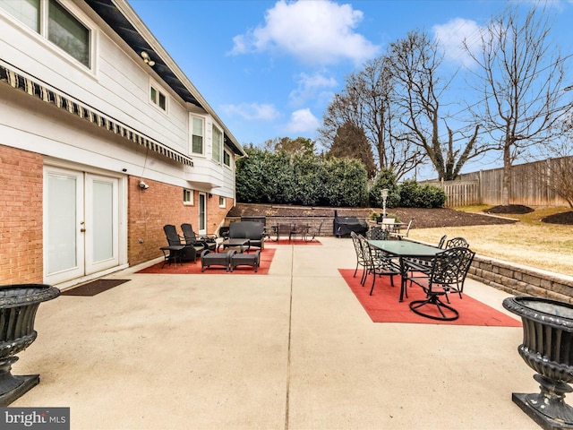 view of patio / terrace with fence, outdoor dining area, and french doors