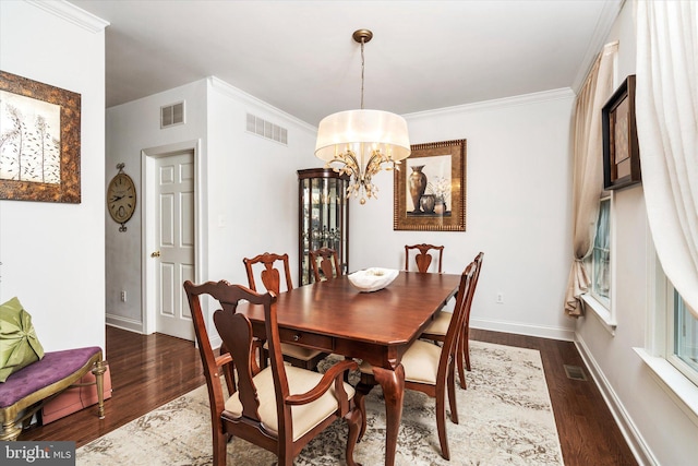 dining room featuring ornamental molding, dark hardwood / wood-style floors, and an inviting chandelier