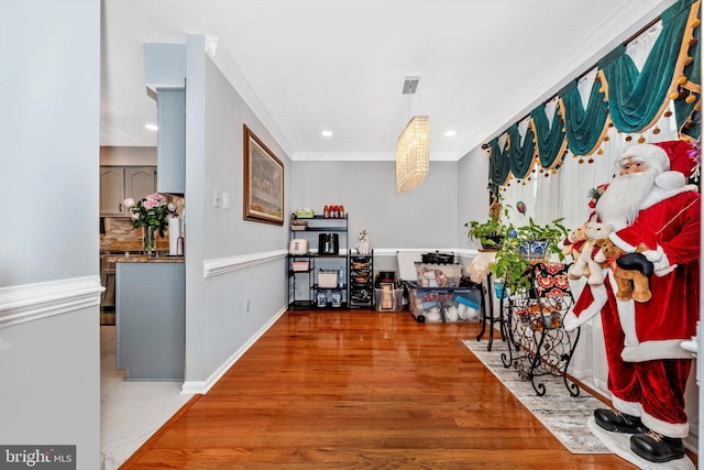 interior space with baseboards, recessed lighting, wood finished floors, and crown molding