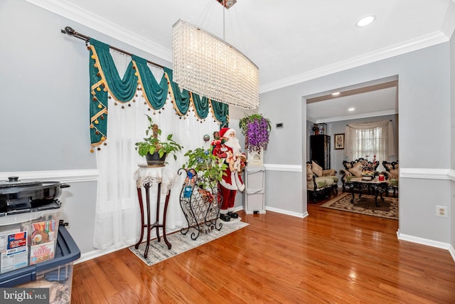 dining area with baseboards, crown molding, and wood finished floors