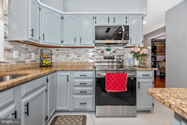 kitchen with light stone counters, marble finish floor, stainless steel appliances, tasteful backsplash, and ornamental molding